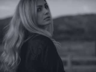 a blonde woman looks back in a fashion film