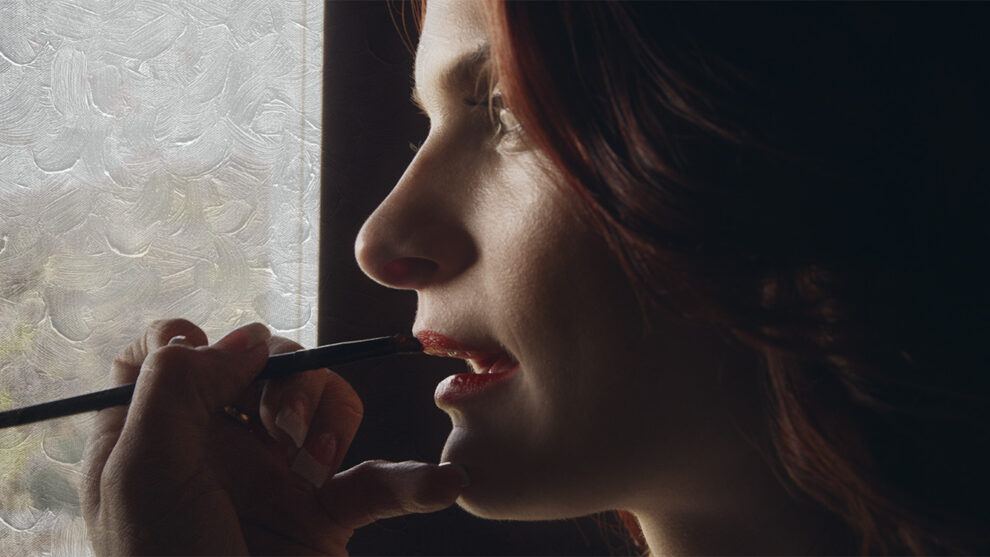 a female readhead actor gets her makeup done by window light